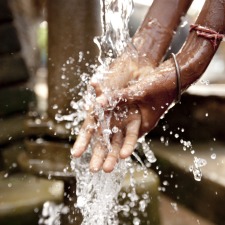 child-washes-hand-in-well-water