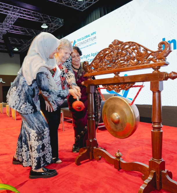 Three presenters hitting a gong to signal the start of the consortium