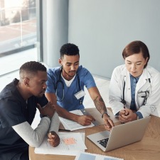 Medical professionals around a laptop