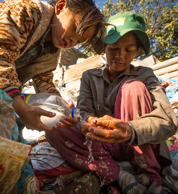 A woman and child in Nepal wash food.