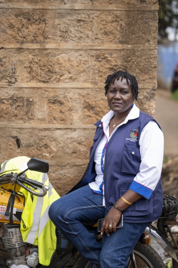 Lillyan Mutua on a motorbike used to deliver vaccines.